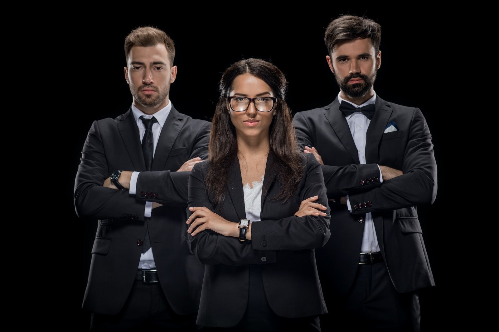 confident businesspeople with crossed arms looking at camera, isolated on black
