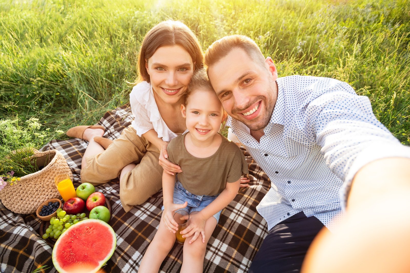 Happy family making selfie sitting in the countryside