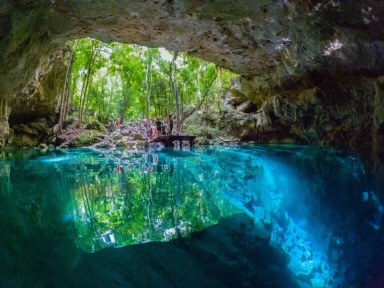 gente parada en plataforma para entrar a cenote